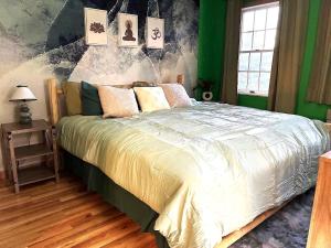 a bedroom with a large bed with green walls at Jurassic Dino Suite Jiminy-Must See Sleeps 4 in Hancock +20 photos
