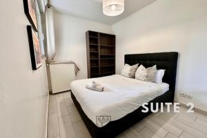 ローニュにあるKAALA STAYS - Group friendly apt Disney and Paris with Free Parkingのベッドルーム1室(大型ベッド1台、黒いヘッドボード付)
