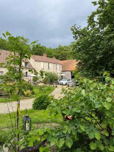 Una vista de un patio con casas y árboles. en Le petit jardin du Coudray, en Étréchy