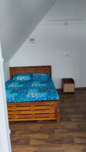 a bedroom with a bed with a blue comforter at Nomadcasa Rooms in Kanthalloor