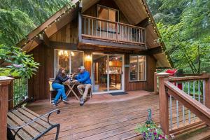 two people sitting at a table on the deck of a cabin at Nisqually Nest at Mount Rainier in Ashford