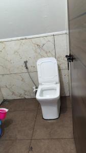 a bathroom with a white toilet in a stall at Nomadcasa Rooms in Kanthalloor