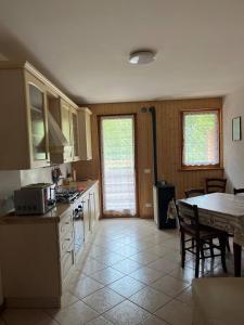 a kitchen with a table and a counter top at Antelao Appart in Masariè +3 photos