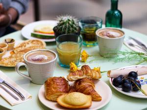 a table topped with plates of pastries and drinks at ibis Styles Evry Courcouronnes Hotel and Events in Courcouronnes