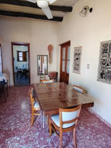 a dining room with a wooden table and chairs at Hostal Dña Tinogasta Casa de Adobe in Tinogasta