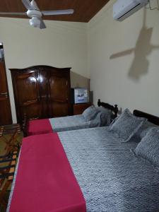 Un dormitorio con una cama grande con una manta rosa. en Hostal Dña Tinogasta Casa de Adobe, en Tinogasta
