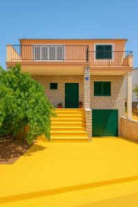 a house with a yellow driveway in front of it at Inter-nautika doo in Jezera
