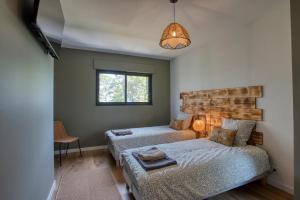 a bedroom with two beds and a window at Le Pech Eternel - Lodge in Sarlat-la-Canéda