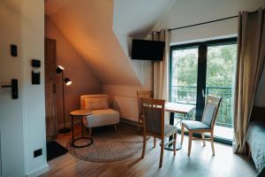 a room with a table and chairs and a window at Althea Ustrzyki Apartmants in Skorka