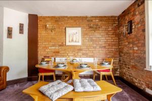 a dining room with a table and chairs and a brick wall at Character 2-Bed Cottage in Gloucester City in Gloucestershire