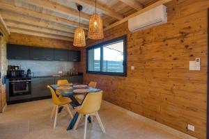 a kitchen and dining room with a table and chairs at Le Pech Eternel - Lodge Spa Cedres in Sarlat-la-Canéda