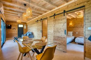 a room with a table and chairs and a bedroom at Le Pech Eternel - Lodge Spa Cedres in Sarlat-la-Canéda