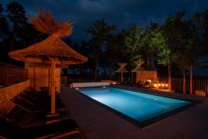 a swimming pool with a straw umbrella next to it at Le Pech Eternel - Spa des Chenes in Sarlat-la-Canéda +3 photos