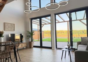 a living room with a chandelier and glass doors at Stodoła HowSmart in Grady Szlacheckie +6 photos
