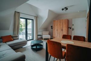 a living room with a table and a couch at Althea Ustrzyki Apartmants in Skorka