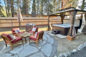 Pine Ridge Retreat في Tahoe Village: فناء مع شرفة وطاولة وكراسي وحوض استحمام