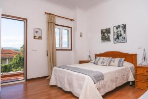 a bedroom with a bed and a large window at Alojamento Da Cunha in Chaves