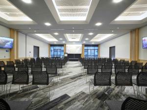 Sala de conferencias con sillas y pantalla de proyector en Novotel Tainui Hamilton, en Hamilton