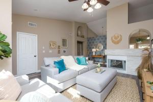 a living room with white furniture and a fireplace at Boho 4BR Retreat with Heated Pool, Spa and Tiki Bar in Gilbert
