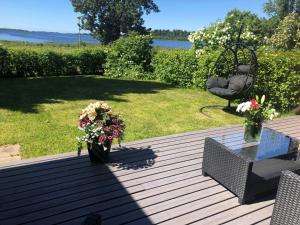 a deck with a chair and a table with flowers at Spacious Apartment for 6 with Sauna in Kemi