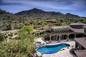 an aerial view of a house with a swimming pool and mountains at Romantic 4BR Hacienda with Pool, Spa and Close to Town in Cave Creek