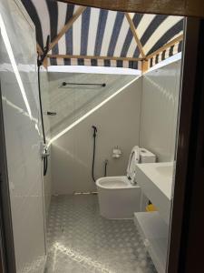 a bathroom with a toilet and a sink at Desert Vibes Camp in Bidiyah
