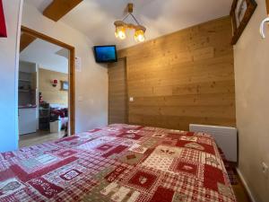 a bedroom with a bed and a wooden wall at Appartement vue exceptionnelle, parking privatif, piscine in Les Orres +58 photos