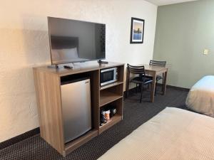 a hotel room with a television and a bed and a desk at Quality Inn By Choice Hotels - West Des Moines - I 235 & I 80 in West Des Moines