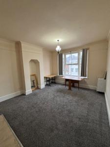 an empty room with a table and a window at Central Gravesend 1 Bed Flat in Gravesend