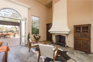 a living room with a fireplace and a table at Chic 3BR Estate with Stables, Pool and Pickleball in Carefree