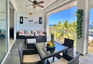 Un comedor con mesa y sillas con vista al mar. en Cozy Beach Front Condo, Pool, en La Puntica de Juan Dolio
