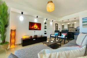 Una sala de estar con un sofá y una chimenea. en Cozy Beach Front Condo, Pool, en La Puntica de Juan Dolio