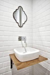 een badkamer met een wastafel en een spiegel aan de muur bij The Cove in Sliema