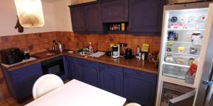 a kitchen with blue cabinets and a refrigerator at Komfort Erdgeschoss Apartment, mit eigener Küche, Bad und WC, inkl Gratis Frühstück, Parkplätze, WiFi und Smart TV in Kassel