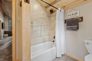 a bathroom with a tub and a toilet at Timber and Tin in Island Park +41 photos
