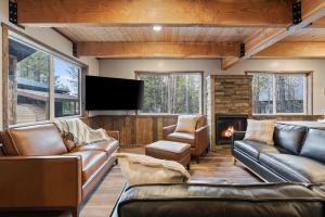 a living room with leather furniture and a flat screen tv at Timber and Tin in Island Park