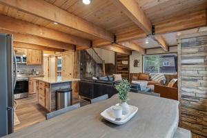 a kitchen and living room with a table in a cabin at Timber and Tin in Island Park