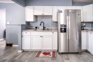 a kitchen with white cabinets and a stainless steel refrigerator at Mineola Bay Lakeview and Access Fully Furnished Monthly and Seasonal Rental in Fox Lake in Fox Lake