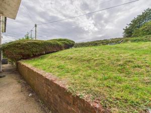 a brick wall next to a field of grass at Spacious 5 BR Brighton Home with Parking in Brighton & Hove +2 photos