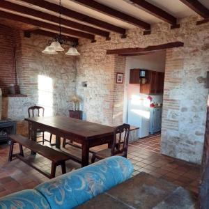 Una sala de estar con una mesa de madera y un sofá. en Gite de PECH ABADEN, en La Celle-sous-Gouzon