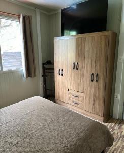 a bedroom with a bed and a large wooden cabinet at Dulce Linas titanes in Araminda