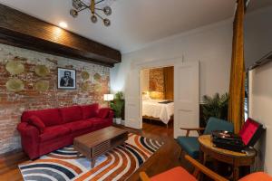 ein Wohnzimmer mit einem roten Sofa und einer Ziegelwand in der Unterkunft 5 New Orleans Themed Units in FQ with Pool in New Orleans + 48 Fotos