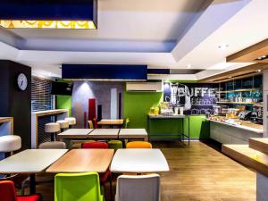 a restaurant with tables and chairs and a kitchen at ibis Budget - Enfield in Sydney