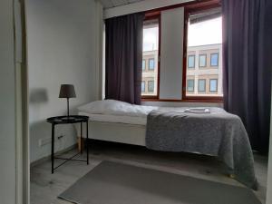 a bedroom with a bed and a large window at Central and Spacious Apartment for 11 in Kemi