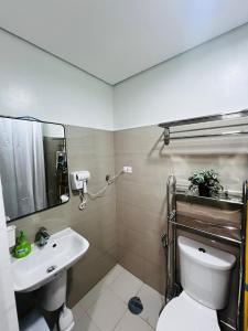 a bathroom with a sink and a toilet and a mirror at MOA GRAND STAY Suite 03 Spacious Unit ! in Manila +9 photos