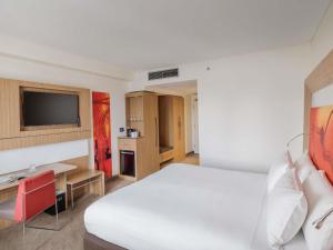 a hotel room with a bed and a television at Novotel Sydney Olympic Park in Sydney