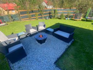 a backyard with a fire pit and chairs and a table at Cabana La Batranu-ciubar&atv in Borşa