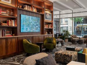 a library with chairs and a tv and books at Sofitel Philadelphia at Rittenhouse Square in Philadelphia