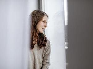 a woman is looking out of a window at ibis budget Berlin Hoppegarten in Hoppegarten