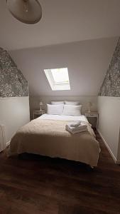 a bedroom with a large bed with a skylight at L'atelier de la Tour - Gite indépendant entièrement équipé in Le Plessis-la-Tour